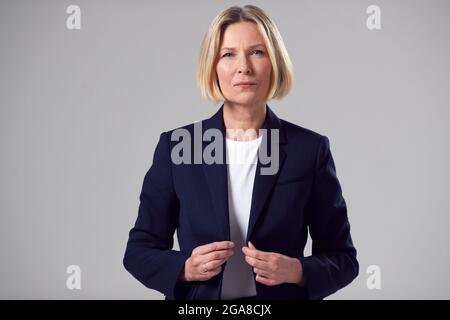 Studio Portrait Von Ernsthaften Reifen Geschäftsfrau Gegen Einfachen Hintergrund Stockfoto