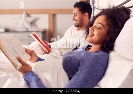 Paar Im Schlafanzug Liegend Im Bett Bücher Zusammen Lesen Stockfoto