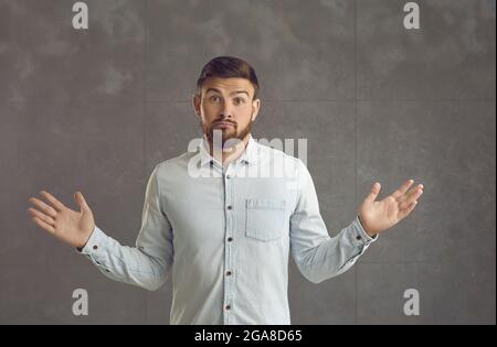 Porträt eines jungen Mannes, der mit den Schultern zuckert und einen verwirrten oder gleichgültigen Gesichtsausdruck hat Stockfoto