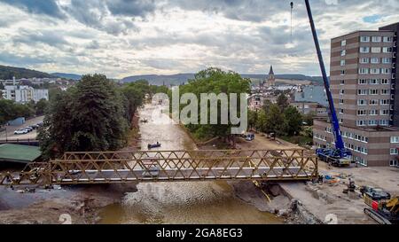 Bad Neuenahr Ahrweiler, Deutschland. Juli 2021. THW-Helfer bauen in Bad Neuenahr eine provisorische Brücke an dem Ort, an dem die Landgrafenbrücke vor der Flutkatastrophe die Ahr überspannt. Die Brücke wird voraussichtlich am Samstag befahrbar sein. (Luftaufnahme mit einer Drohne) Quelle: Thomas Frey/dpa/Alamy Live News Stockfoto