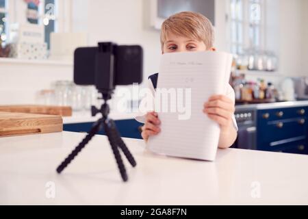 Junge Zu Hause Trägt Schuluniform Mit Online-Unterricht Per Videoanruf Auf Dem Mobiltelefon Stockfoto