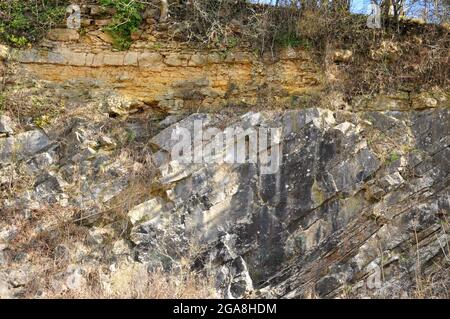 De la Beche geologische unconformity Gelb unterlegen Oolite Kalkstein ruht auf einem steil eintauchenden grau Karbon Kalkstein. Somerset UK Stockfoto