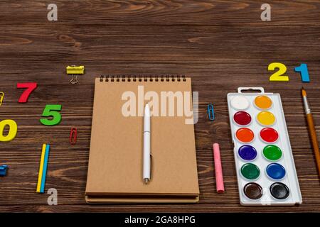 Schulbedarf, Bürobedarf auf dunklem Holz. Stockfoto
