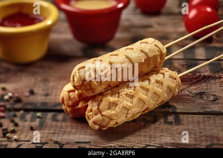 Maishunde auf Spieße auf rustikaler Holzoberfläche Stockfoto