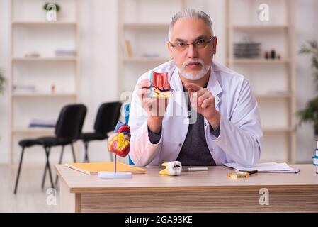 Alte Zahnarztlehrerin sitzt im Klassenzimmer Stockfoto