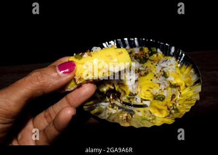 Khandvi ein traditionelles und authentisches Gujarati-Gericht, das als herzhafte Snacks serviert wird. Temperiert und garniert mit geriebener Kokosnuss, grünem Chilly und Sesam Stockfoto