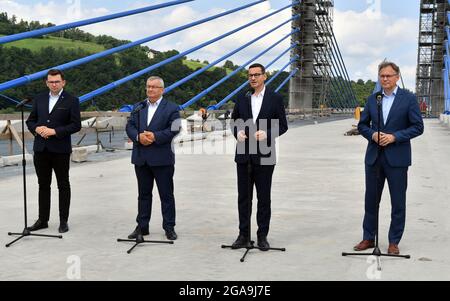 Kurow, Polen. Juli 2021. MA?opolska Voivode Lukasz Kmita (L) Minister für Infrastruktur Andrzej Adamczyk (2L) Premierminister Mateusz Morawiecki (3L) Arkadiusz Mularczyk (4L) sind auf der Baustelle einer neuen Brücke in Kurow am DK 75 in der Nähe von Nowy Sacz in Ma?opolska zu sehen.Quelle: SOPA Images Limited/Alamy Live News Stockfoto