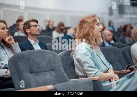 Junge Geschäftsfrau, die aufmerksam dem Redner zuhört. Stockfoto