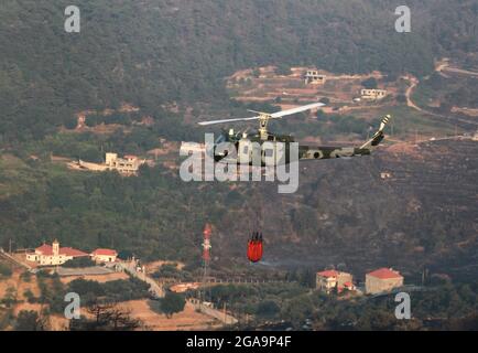 Akkar, Libanon. Juli 2021. Ein Hubschrauber der libanesischen Armee entfacht am 29. Juli 2021 ein Waldfeuer in Akkar, Nordlibanon. Das massive Feuer, das im nordlibanesischen Dorf Quubaiyat ausbrach, wütete in der Region noch am zweiten Tag, berichtete eine lokale Nachrichtenstelle am Donnerstag. Quelle: Khaled/Xinhua/Alamy Live News Stockfoto