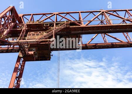 Laufstege und Treppen mit Geländern als Teil einer riesigen, offenen Industriestruktur, die sich vor einem wunderschönen blauen Himmel, einem horizontalen Aspekt, abhebt Stockfoto