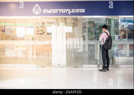 BANGKOK THAILAND 4. JULI 2021: Trotz der Coronavirus-Epidemie in Bangkok wartet ein Mann weiterhin auf die öffentliche Bank, die an diesem Tag arbeitet. Stockfoto