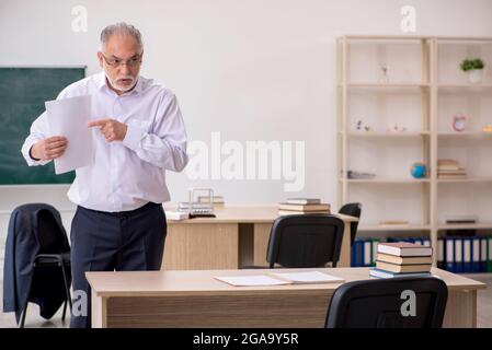 Alte Lehrerin vor der Tafel Stockfoto