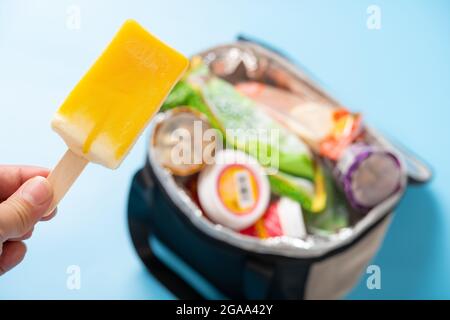 Mann, der einen Eiszapfen mit Isolierpackung voller Eis und Eiszapfen hält Stockfoto