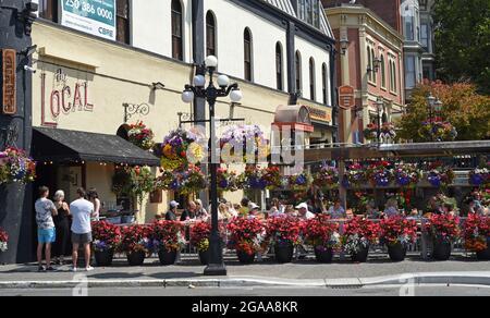 Die Außenterrasse eines Restaurants ist stark mit Topfblumen und hängenden Blumenkörben am Bastion Square in Victoria, British Columbia, an der V, dekoriert Stockfoto