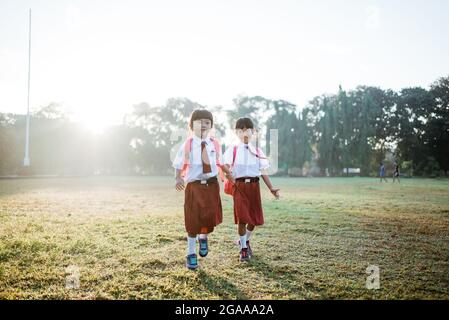 Weibliche asiatische primäre erste Grader Student gehen zusammen Stockfoto