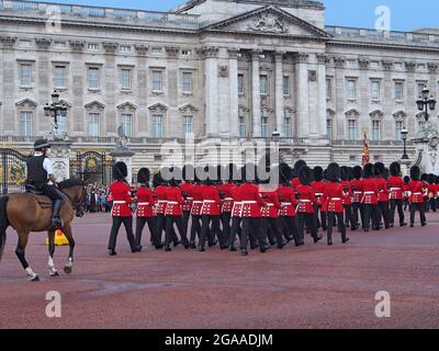 London, England: Wachwechsel vor dem Buckingham Palace mit Erwachern in roten Mänteln, die Gewehre mit Bajonetten tragen Stockfoto