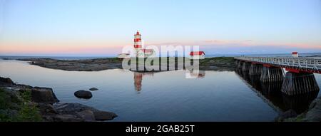 Panoramablick auf den Leuchtturm von Pointe-des-Monts bei Sonnenuntergang mit Spiegelungen im Meer, Cote-Nord, Quebec Stockfoto