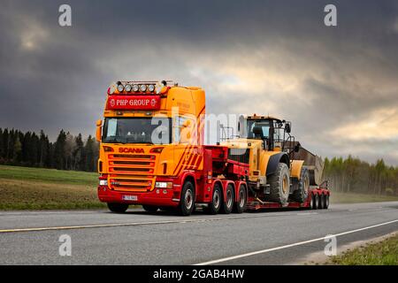 Kundenspezifischer Scania G580 LKW der PHP Group vor Schwanenhals-Anhänger transportiert Cat Radlader auf Highway 10. Tammela, Finnland. 14.Mai 2021. Stockfoto