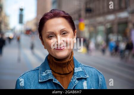 Frau in der Stadt. Porträt einer älteren Frau, die aus nächster Nähe lächelt Stockfoto