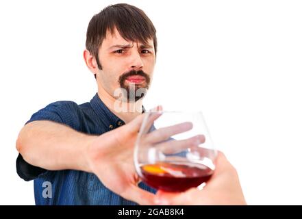 Mann lehnt Glas Brandy auf dem weißen Hintergrund ab Stockfoto