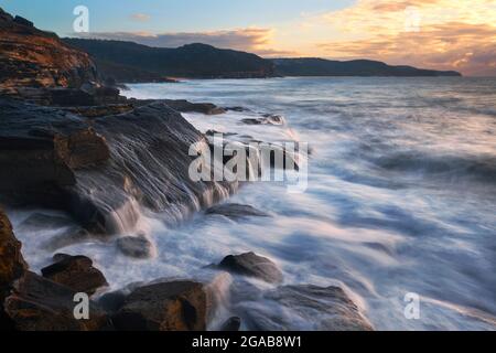 Wasser fließt entlang der Küste entlang die Felsen hinunter Stockfoto