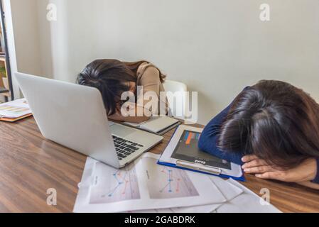 Müde und frustriert Freiberufler schlafen auf dem Arbeitstisch Stockfoto