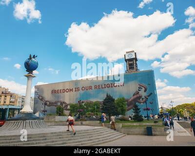 Kiew, Ukraine-28. April 2018: Menschen wandern auf dem Unabhängigkeitsplatz (Maidan Nezalezhnosti) in Kiew, Ukraine. Freiheit ist unsere Religion Banner auf t Stockfoto