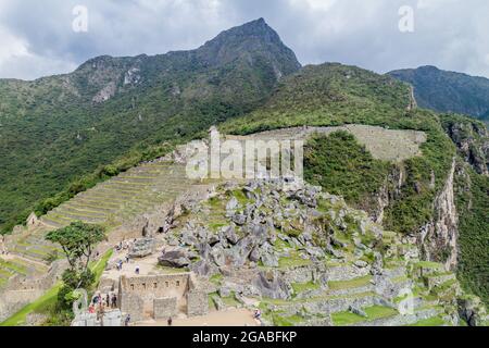 MACHU PICCHU, PERU - 18. MAI 2015: Besuchermassen im Haus des Hohenpriesters in den Ruinen von Machu Picchu, Peru. Stockfoto