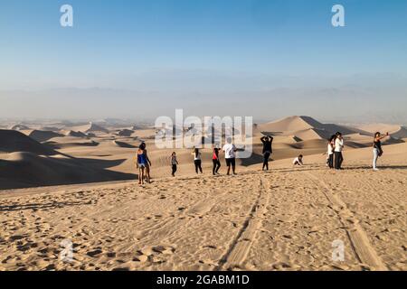 HUACACHINA, PERU - 1. JUNI 2015: Touristen besuchen die Dünen in der Wüste Huacachina, Peru Stockfoto