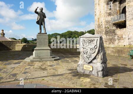 Statue von David Lloyd George und einem Steinsockel zum Gedenken an Kieffer Moore im Caernarfon Castle Square Wales Stockfoto