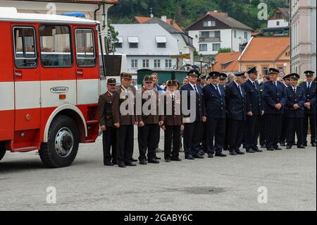 Die tschechischen Freiwilligen-Feuerwehrleute (blaue Uniformen) stehen mit ihren österreichischen Kollegen (braune Uniformen) aus dem Bezirk Freistadt zusammen, während sie auf dem Hauptplatz von Rožmberk nad Vltavou, einer kleinen Stadt an der Moldau im südböhmischen Bezirk Český Krumlov, auf den Beginn einer Bürgerzeremonie warten. Tschechien / Tschechische Republik. Grenzüberschreitende Freundschaftsbeziehungen zwischen den beiden Brigaden sind vor dem Fall der Berliner Mauer und der Samtenen Revolution von 1989 in der ehemaligen Tschechoslowakei entstanden. Stockfoto