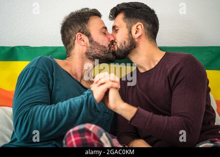 Glücklich Gay Paar mit romantischen Momenten küssen im Bett - homosexuelle Liebesbeziehung und Gleichstellung der Geschlechter Konzept Stockfoto