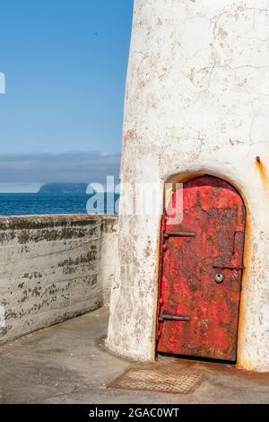 Alte, verwitterte Tür am Leuchtturm am Eingang zum hafen von girvan mit ailsa craig im Hintergrund an der Westküste schottlands, Stockfoto