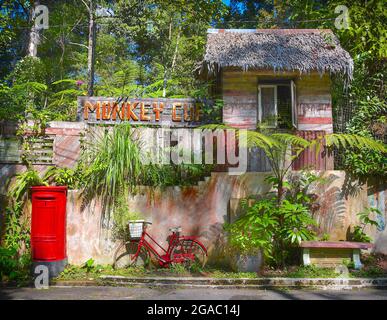 Ein im Retro-Stil gestaltetes Outdoor-Café in Penang, Malaysia, mit einem altmodischen britischen roten Briefkasten und einem rustikalen Vintage-Fahrrad draußen. Stockfoto