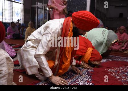 KALKUTTA, INDIEN - 09. Mai 2019: Nahaufnahme eines Indianers in traditioneller Kleidung und rotem Turban in gurudwara Beten. Hochzeitsansicht Stockfoto