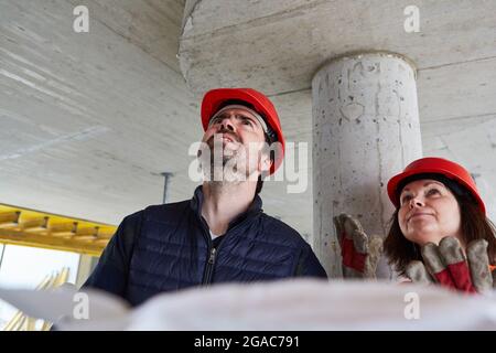 Der Architekt und der Bauvermesser finden bei einer Inspektion auf der Baustelle im Rohbau Baumängel Stockfoto