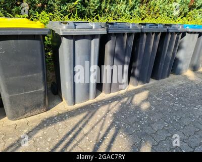 Viele Mülltonnen stehen in einer Reihe Stockfoto