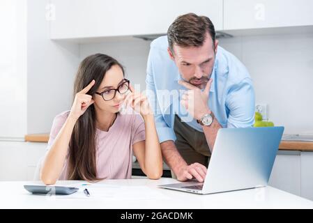 Junges Paar berechnet Geld zu Hause. Finanzrevision, Haushaltskonzept für Privathaushaltsmittel Stockfoto