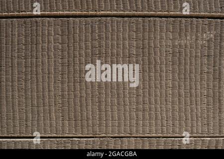 Strukturierte Rattanmatte aus Korbgeflecht. Dekorative Naturwand. Eco-Hintergrund. Umweltschutz, umweltfreundliches Hauskonzept Stockfoto