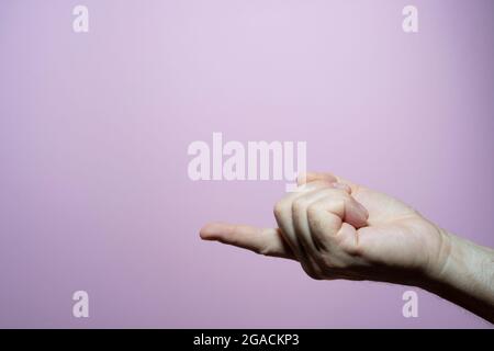 Der Finger der Hand eines Mannes mit einem rosa Hintergrund Stockfoto