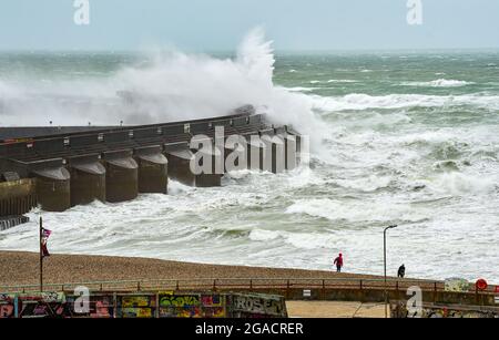 Brighton UK 30. Juli 2021 - Spaziergänger am Strand an der Westwand der Brighton Marina, während Sturm Evert durch das Land fegt und Windgeschwindigkeiten von bis zu 60 km/h in einigen Gegenden prognostiziert werden : Credit Simon Dack / Alamy Live News Stockfoto