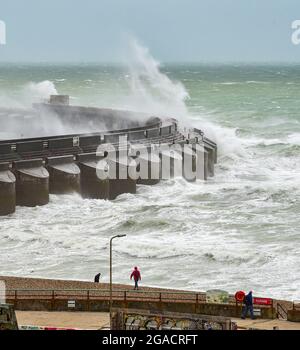 Brighton UK 30. Juli 2021 - Spaziergänger am Strand an der Westwand der Brighton Marina, während Sturm Evert durch das Land fegt und Windgeschwindigkeiten von bis zu 60 km/h in einigen Gegenden prognostiziert werden : Credit Simon Dack / Alamy Live News Stockfoto