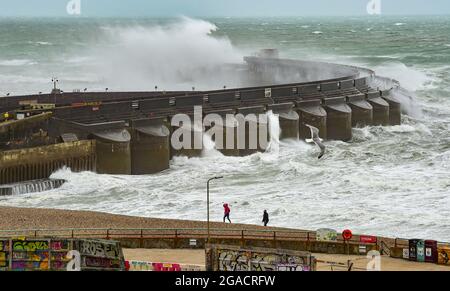 Brighton UK 30. Juli 2021 - Spaziergänger am Strand an der Westwand der Brighton Marina, während Sturm Evert durch das Land fegt und Windgeschwindigkeiten von bis zu 60 km/h in einigen Gegenden prognostiziert werden : Credit Simon Dack / Alamy Live News Stockfoto