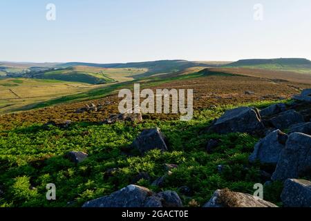 An einem hellen, nebligen Sommermorgen im Derbyshire Peak District entlang der von Felsen übersäten Hänge von Surprise View und über Hathersage Moor. Stockfoto