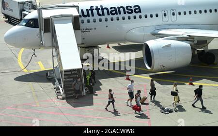 30. Juli 2021, Hessen, Frankfurt/Main: Flugreisende verlassen einen Lufthansa Airbus A320neo auf dem Vorfeld des Frankfurter Flughafens. Für diejenigen, die aus ihren Sommerferien zurückkehren, werden ab diesem Sonntag neue Testverpflichtungen zum Schutz vor einer Corona-Ausbreitung in Kraft treten. Foto: Arne Dedert/dpa Stockfoto