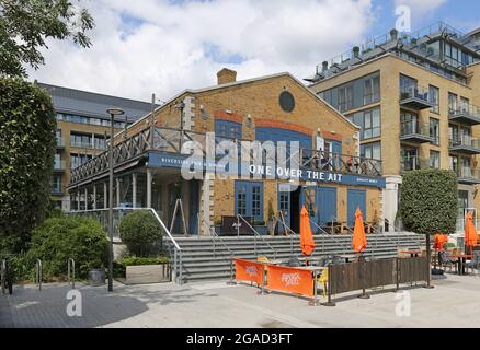 Neues Wohngebiet am Flussufer an der Kew Bridge, West-London, an der Themse. Zeigt eine über dem Ait Cafe/Bar mit Wohnblöcken dahinter. Stockfoto