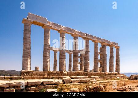 Der antike griechische Tempel von Poseidon am Kap Sounion, dorische Säulen und Ruinen auf dem Hügel mit kristallblauem Himmel Hintergrund. Stockfoto