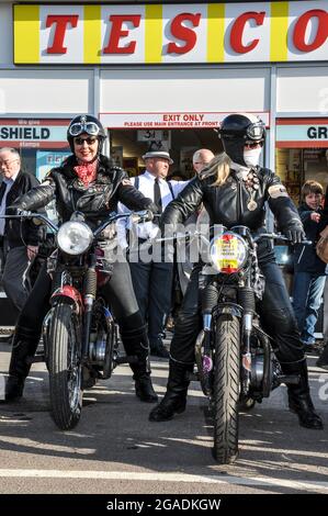 Motorradfahrerinnen in Retro-Leder im Goodwood Revival vor dem Retro Tesco Shop, Store. Vintage, klassisch, zeitlos. Gehen Sie zurück in die Zeit Stockfoto