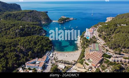 Luftaufnahme des Strandes von Port Sant Miquel am Nordufer der Insel Ibiza in Spanien - isolierte Bucht mit großen Hotels am Hang Stockfoto