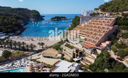 Luftaufnahme des Strandes von Port Sant Miquel am Nordufer der Insel Ibiza in Spanien - isolierte Bucht mit großen Hotels am Hang Stockfoto